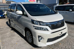 Foto do exterior dianteira esquerda de um carro Toyota Vellfire ano 2013 à venda pela Revendedora Golden Motors em Oizumi-machi, Gunma